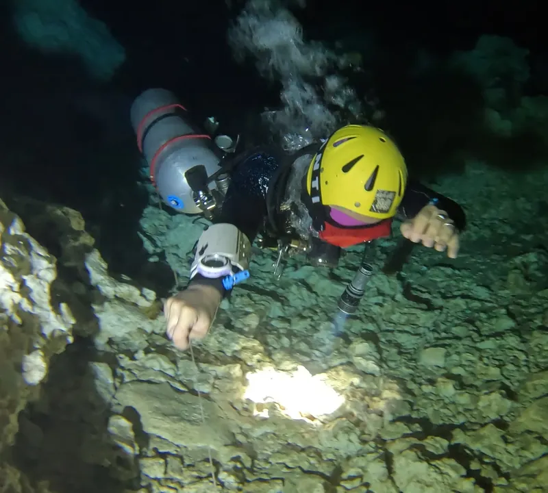 Cave diving training session demonstrating buoyancy control and equipment configuration during a zero visibility exit