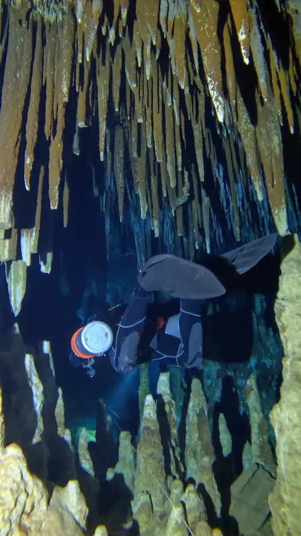 Close up of a technical diver checking their dive computer in dark water