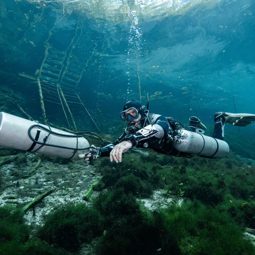 Technical cave diver practicing sidemount skills during training in a cenote