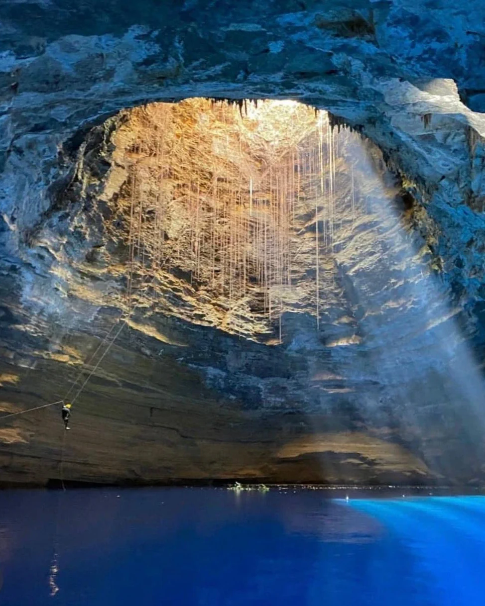 Explorer descending into a flooded sinkhole system in Brazil.