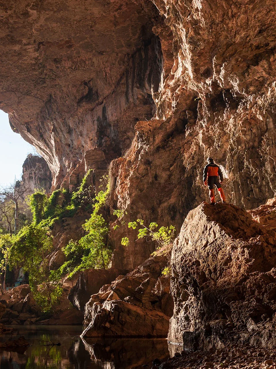 Explorer standing inside a massive cave system in Terra Ronca, Brazil.